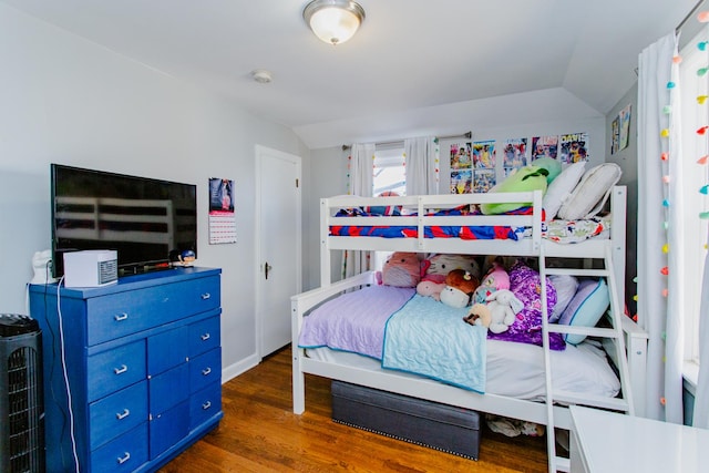 bedroom featuring wood finished floors and vaulted ceiling