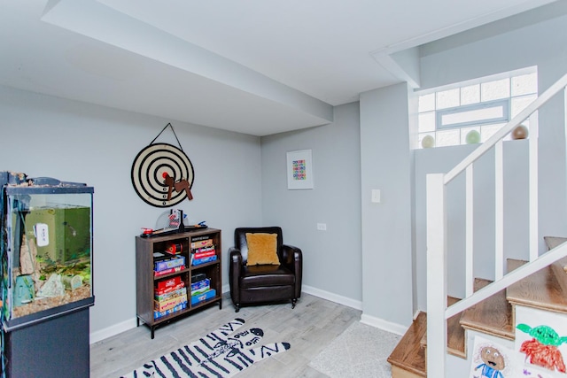 living area featuring stairway, baseboards, and wood finished floors