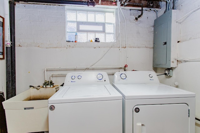 laundry area featuring electric panel, a sink, laundry area, and washing machine and clothes dryer