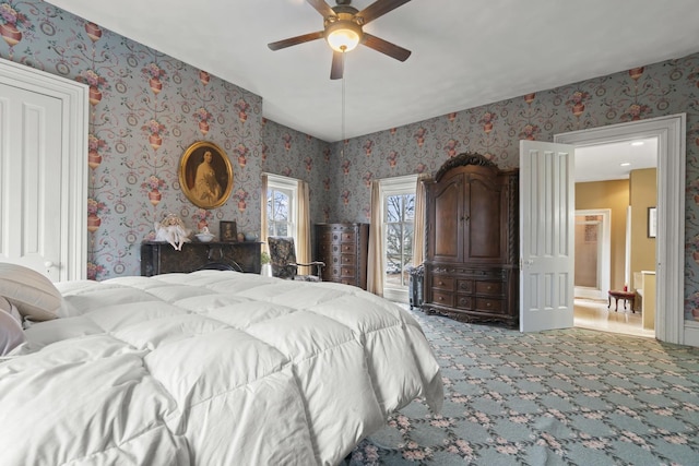 carpeted bedroom with ceiling fan and wallpapered walls