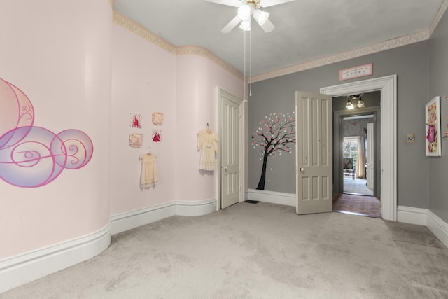 empty room with carpet, baseboards, and ceiling fan