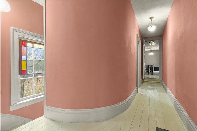 hallway featuring baseboards and hardwood / wood-style floors