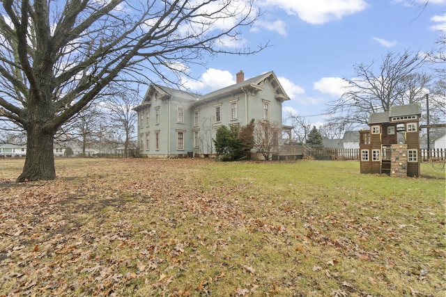 view of property exterior featuring a chimney and a yard