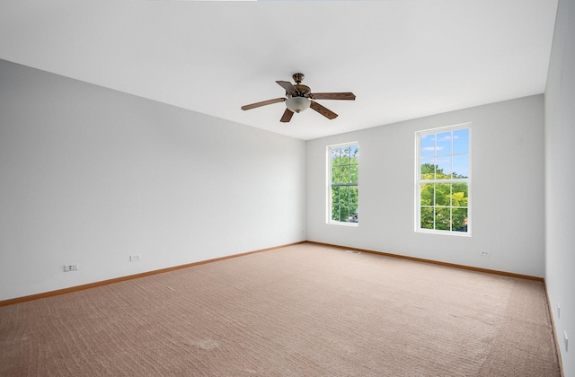 unfurnished room with ceiling fan, baseboards, and carpet