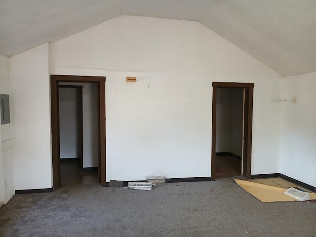 carpeted spare room with baseboards and lofted ceiling