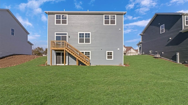 rear view of property with a deck, stairway, and a lawn