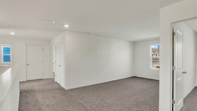 carpeted spare room with a wealth of natural light, baseboards, and recessed lighting