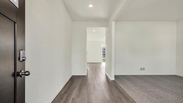 hallway featuring recessed lighting, visible vents, baseboards, and dark wood-type flooring