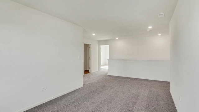 spare room with visible vents, carpet flooring, recessed lighting, and baseboards