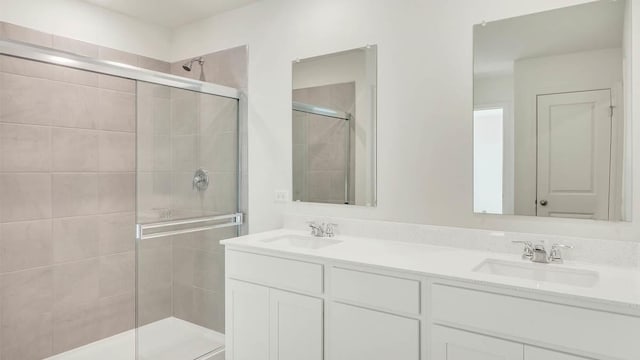 full bath featuring a sink, a stall shower, and double vanity