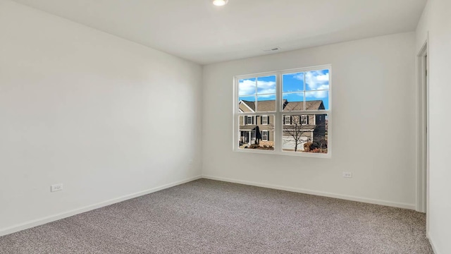 unfurnished room with visible vents, baseboards, and carpet floors