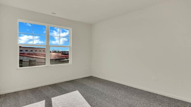 spare room featuring baseboards and carpet floors