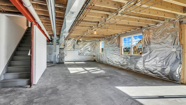 basement with heating unit and stairs