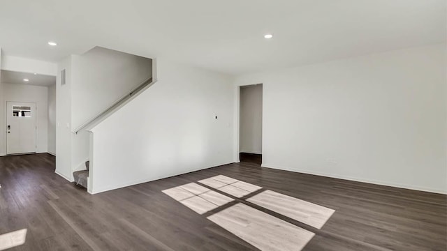 spare room featuring stairway, recessed lighting, wood finished floors, and baseboards