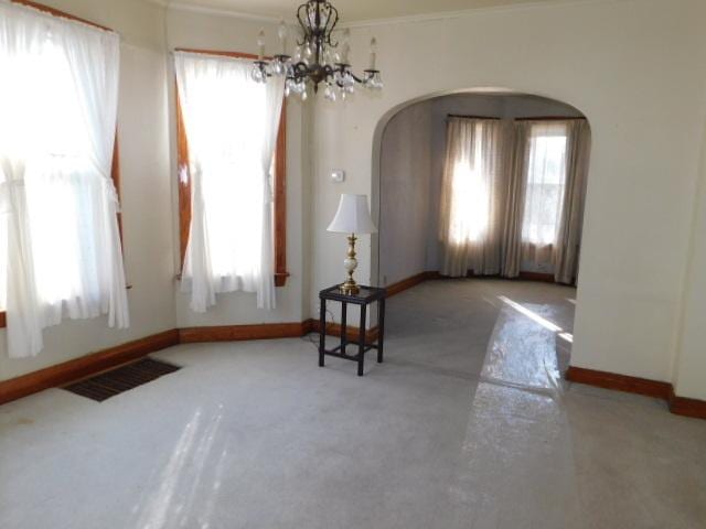 sitting room with baseboards, arched walkways, visible vents, and a chandelier