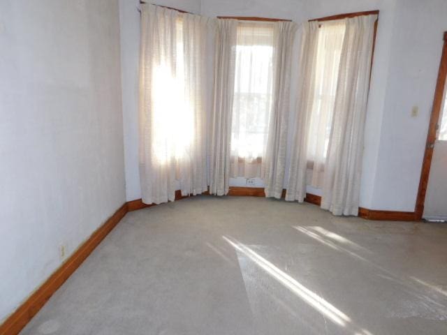 unfurnished room featuring carpet flooring and baseboards