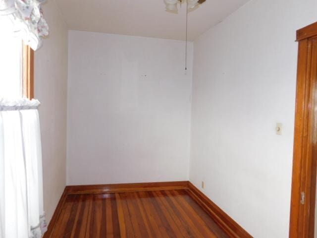 unfurnished room with baseboards and wood finished floors