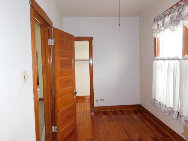 empty room featuring wood finished floors and baseboards