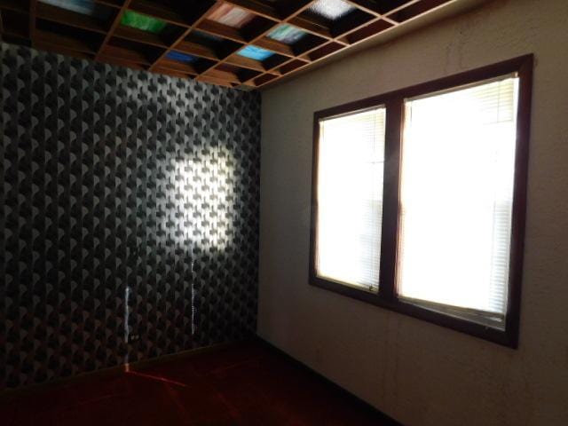 spare room featuring a wealth of natural light, wet bar, and coffered ceiling