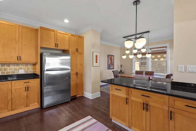 kitchen featuring freestanding refrigerator, ornamental molding, hanging light fixtures, dark wood-type flooring, and tasteful backsplash