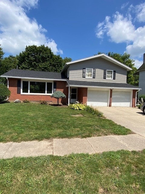 split level home with brick siding, concrete driveway, a garage, and a front yard