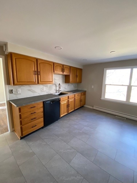 kitchen with a sink, a baseboard heating unit, black dishwasher, dark countertops, and baseboards