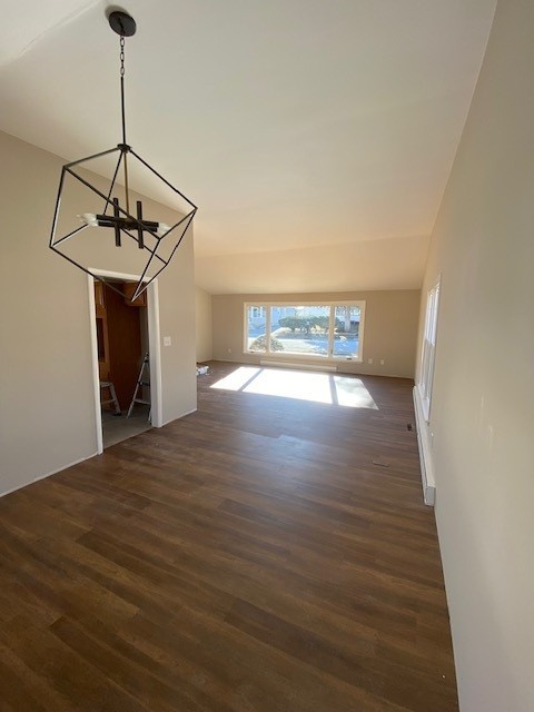 unfurnished dining area with a notable chandelier and dark wood-type flooring