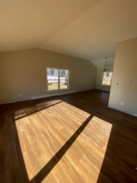 spare room with a notable chandelier, dark wood-type flooring, lofted ceiling, and a baseboard radiator