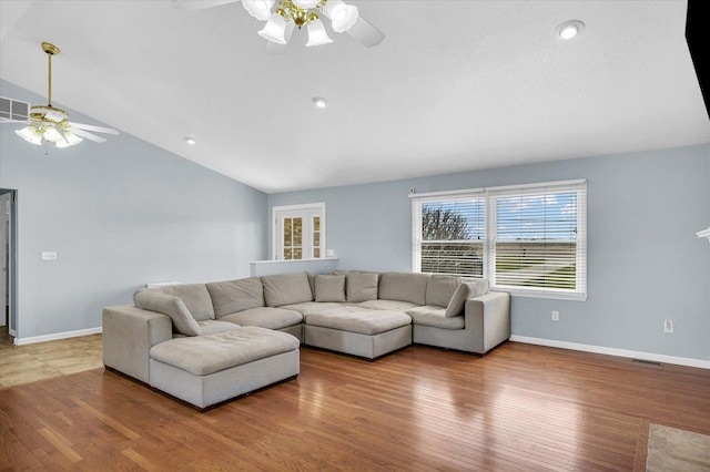 living area featuring baseboards, lofted ceiling, wood finished floors, and a ceiling fan