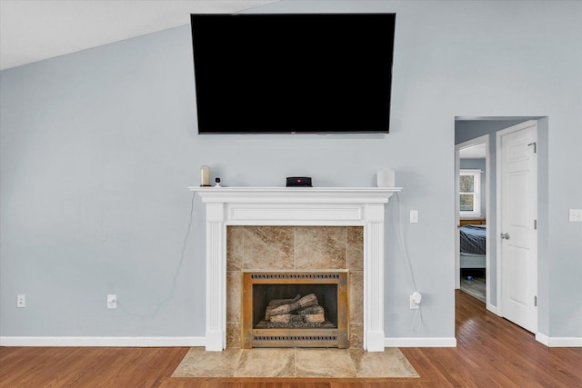 unfurnished living room featuring baseboards, a fireplace, and wood finished floors