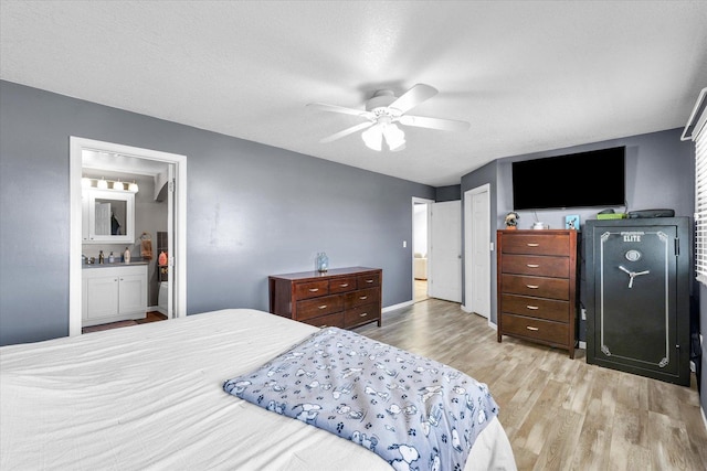 bedroom with wood finished floors, ceiling fan, ensuite bathroom, and a textured ceiling