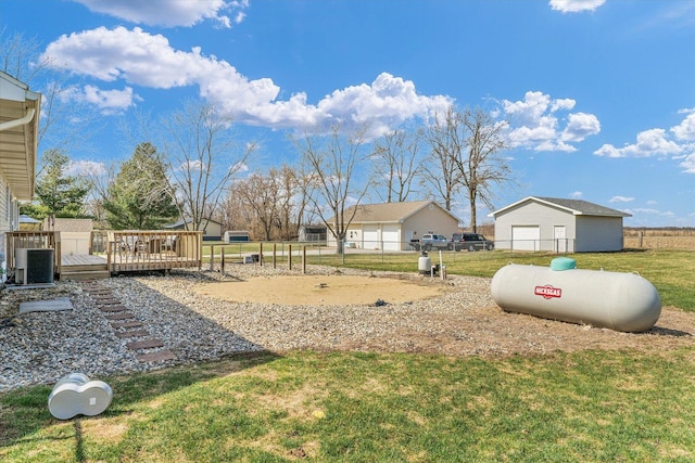 view of yard featuring a deck, fence, and central AC