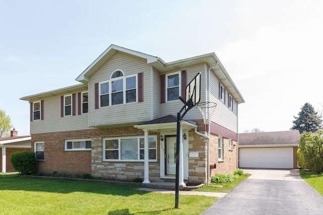 view of property featuring a front yard, stone siding, brick siding, and a detached garage