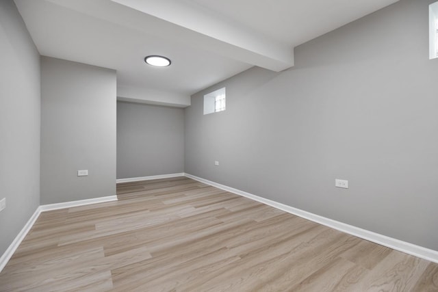 below grade area featuring light wood-style flooring and baseboards