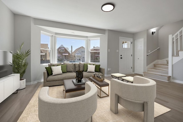 living area featuring stairs, wood finished floors, and baseboards