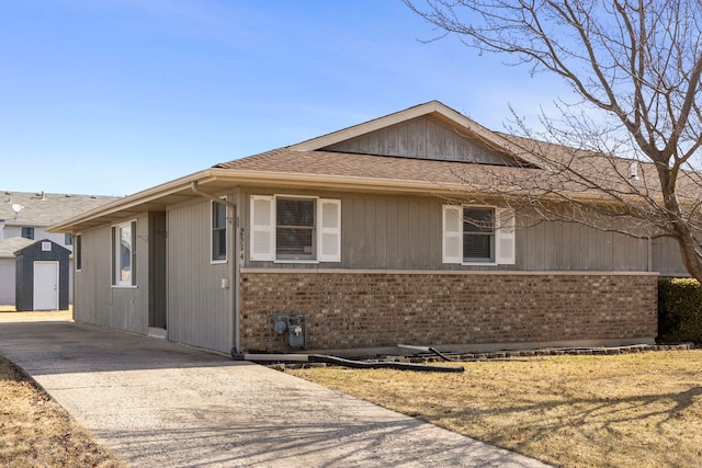 single story home with brick siding, driveway, and roof with shingles