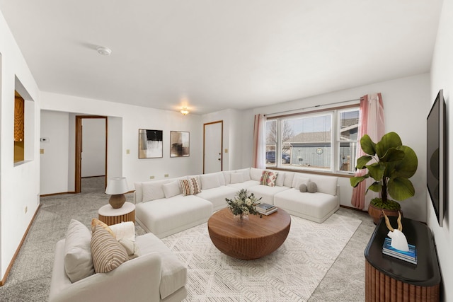 carpeted living area with baseboards