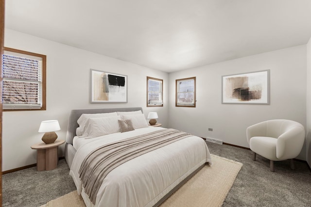 carpeted bedroom featuring visible vents, multiple windows, and baseboards