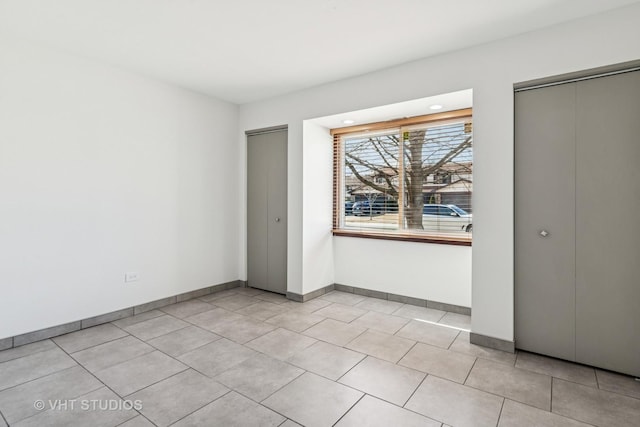 interior space with light tile patterned flooring and baseboards