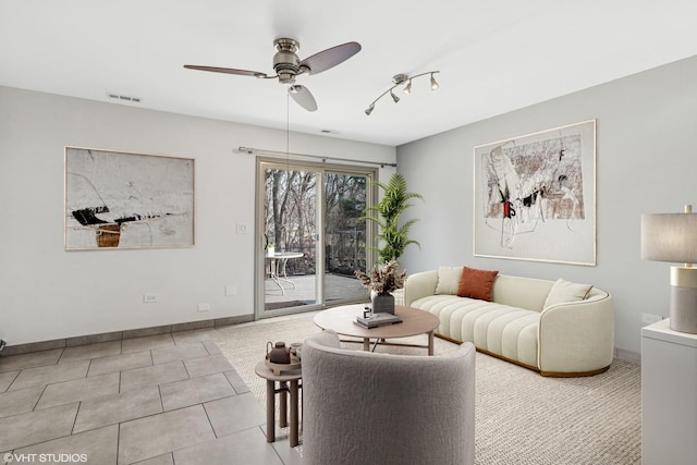 tiled living room with a ceiling fan, visible vents, and baseboards