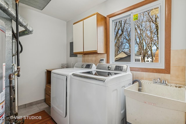 washroom featuring a sink, cabinet space, independent washer and dryer, and light tile patterned floors