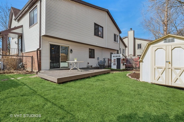 rear view of house with a storage shed, a yard, and fence