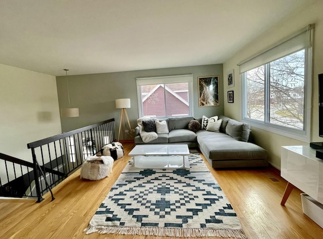 living room with plenty of natural light, wood finished floors, and baseboards