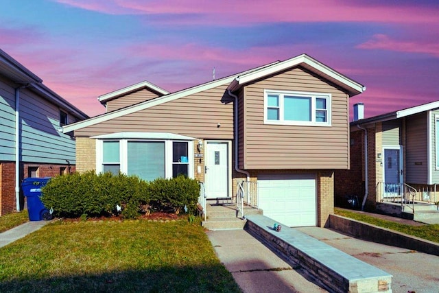 tri-level home featuring brick siding, a front yard, and a garage