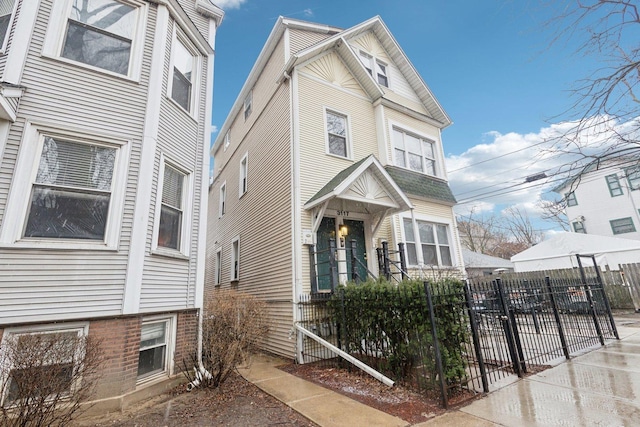 view of front of home featuring a fenced front yard and brick siding