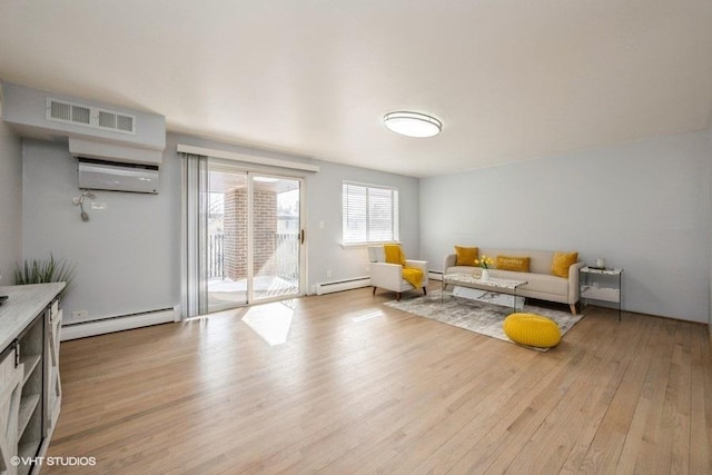 sitting room with a baseboard heating unit, visible vents, light wood finished floors, and a wall mounted AC