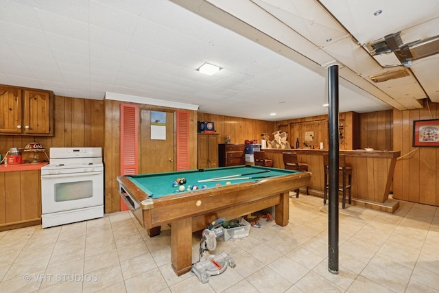 playroom featuring a bar, billiards, and wood walls