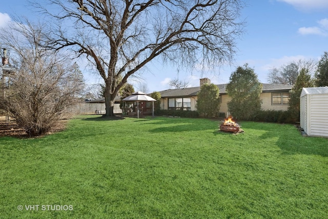 view of yard with a gazebo, a storage unit, a fire pit, and an outdoor structure