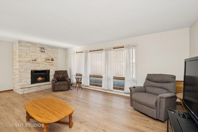 living area with light wood-style flooring and a fireplace