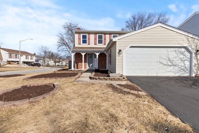 view of front of home featuring driveway, a porch, an attached garage, a chimney, and brick siding